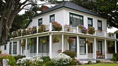 a large white house with flowers on the balconies