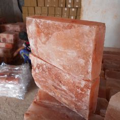 a large block of pink colored soap sitting on top of a wooden table next to boxes