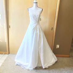 a white wedding dress on display in front of a door