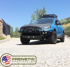 a blue truck parked on the side of a road