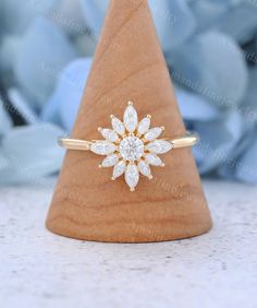 a diamond ring sitting on top of a wooden cone