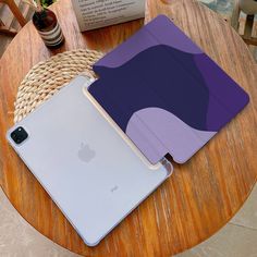 an apple ipad is sitting on top of a table next to a purple and blue case