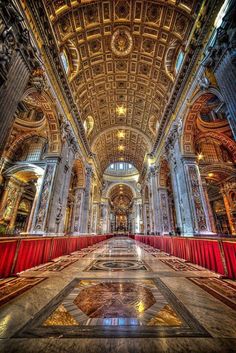 the inside of a large building with red and gold curtains on it's sides