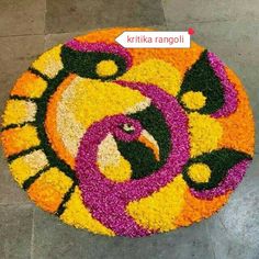 a colorful flower arrangement on the ground in front of a building with an eagle face painted on it