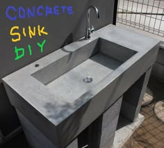 a concrete sink sitting on top of a cement counter next to a sign that says concrete sinks diy