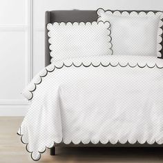 white bedding with scalloped edges and black trim