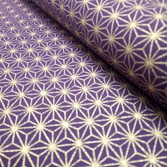 a close up shot of a purple and white fabric with geometric design on the side