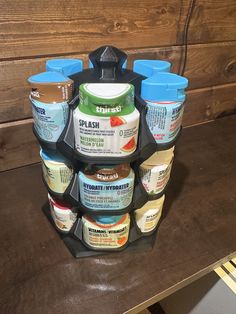 several jars of yogurt are stacked up on a shelf in front of a wooden wall