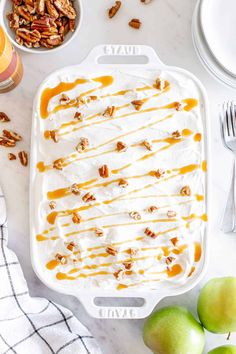 an ice cream sundae with caramel drizzle and pecans on the side