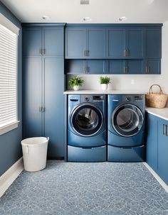 a washer and dryer in a laundry room with blue cabinets on the walls