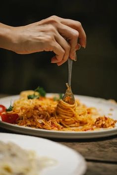 a person is eating spaghetti on a plate