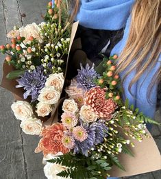 a woman holding a bouquet of flowers in her hands