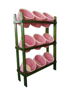 three tiered shelf with pink and white striped baskets on it's sides, against a white background