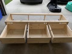 three wooden drawers are stacked on top of each other in front of a garage door