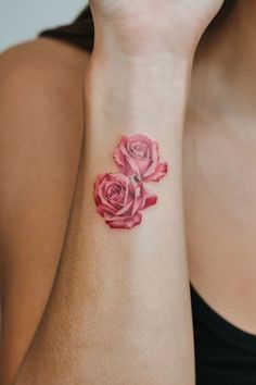 a woman with a pink rose tattoo on her wrist