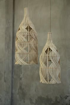 two hanging lights made out of woven material, one is white and the other is beige