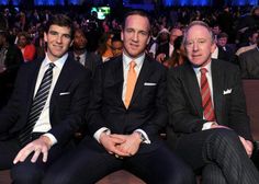 three men sitting next to each other in front of an audience at a business event