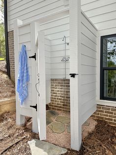 an open white door on the side of a house with a blue towel hanging from it