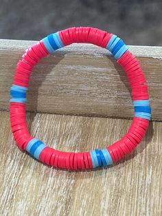 Brighten up your day with our vibrant and playful bracelet! Crafted from colorful, disc-shaped beads in lively shades of pink and blue, this accessory is perfect for adding a pop of color to any outfit. Whether you're heading to a summer festival, a casual brunch, or just want to bring a bit of cheer to your everyday look, this bracelet is your go-to piece. Lightweight and stretchy, it ensures a comfortable fit for all wrist sizes. Treat yourself or gift it to a friend for an instant mood booster! Multicolor Plastic Summer Bracelets, Fun Plastic Jewelry For The Beach, Pink Heishi Beads Friendship Bracelets For Beach, Pink Heishi Beads Friendship Bracelets For Vacation, Red Beaded Bracelets For Summer Vacation, Vibrant Handmade Pink Bracelet, Playful Pink Bracelets For Festival, Playful Pink Bracelets For Festivals, Pink Bracelet For Summer Festival