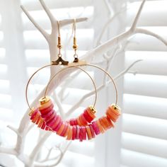 These gorgeous orange and gold Heishi hoop earrings are made from coloured natural freshwater shells, ideal for adding drama to any outfit! Perfect for a beach holiday or festival, wedding or special occasion! Hoops and earring hooks are made from plated gold.  Each pair of earrings has been handmade by Mizzle & Tink. Should you want a certain colour way or order of colours, please do get in touch as I can always make a bespoke pair! Earrings are packaged in a smart black earring box, like the o Handmade Small Hoop Earrings For Vacation, Handmade Small Hoop Jewelry For Vacation, Orange Small Hoop Jewelry For Summer, Trendy Gold Beaded Earrings For Beach, Handmade Coral Jewelry For Vacation, Handmade Coral Jewelry For Summer, Gift Heishi Bead Earrings, Trendy Small Hoop Earrings For The Beach, Trendy Gold Hoop Earrings For Vacation