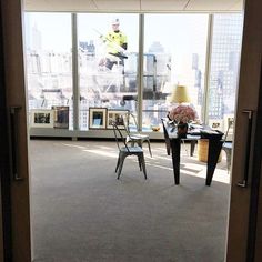 an open door leading to a room with large windows and a view of the city