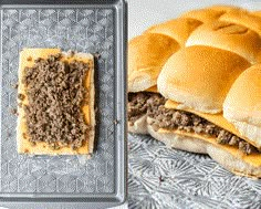 two buns with cheese and ground meat on them next to a baking pan filled with rolls