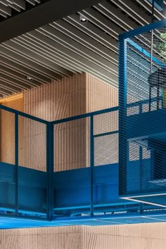 a man riding a skateboard down the side of a blue fenced walkway next to a tall building