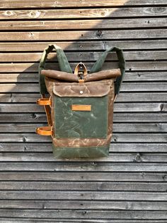 "This pack is constructed out of a British waxed canvas for the corpus in the color burned umber, and olive green heavy weight waxed canvas for the bottom, outside pocket and padded shoulder straps. I made it for everyday use , with padded waxed canvas straps and leather strap with buckle closure and clasp.Roll to close top and large outside pocket. On one side you've got detachable and adjustable leather straps, to carry your jacket on Yogamat This rucksack is fully lined with a blue cotton fab