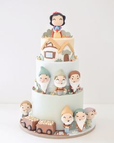 a three tiered cake decorated with figurines of people riding on top of it