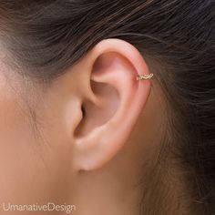 a woman's ear is shown with a small gold nose pin in the middle