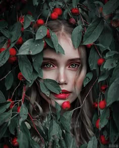 a woman with long hair and red lips is surrounded by leaves, berries and berries