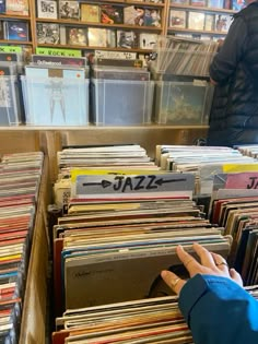 a person reaching for records in a record store