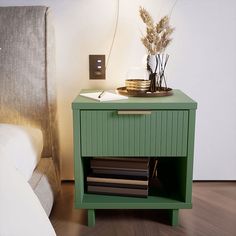 a green nightstand with drawers on it next to a bed