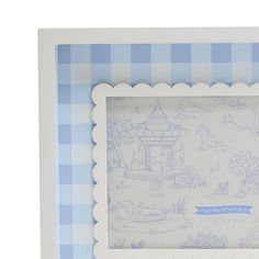 a blue and white checkered photo frame with an image of a house on it