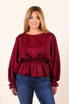 Add feminine flair to your wardrobe with a delicate blouse featuring a round neckline, an elastic waist peplum hem and baby bell sleeves. Pair it with some skinnies and cute booties or pumps. -Color: Burgundy -Relaxed Fit -Stretchy -Round Neckline -Long Sleeves with Elastic Cuffs -Elastic Waistband -Back Keyhole with Neckline Button Closure -Content:100% Polyester -Imported -Runs true to size -Model is wearing 5'5" 36-30-40 and wearing a size small Fall Ruffled Peplum Blouse, Chic Fall Peplum Top, Fall Puff Sleeve Peplum Top With Ruffles, Fall Peplum Top With Ruffles And Puff Sleeves, Fall Peplum Top With Puff Sleeves And Ruffles, Chic Peplum Top With Ruffle Hem For Fall, Chic Fall Peplum Top With Puff Sleeves, Chic Fall Peplum Top With Ruffle Hem, Fall Balloon Sleeve Peasant Top With Ruffles