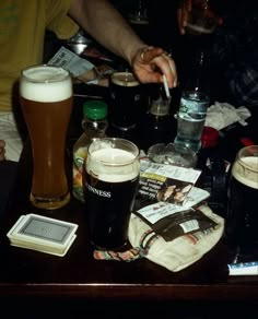 a table topped with lots of different types of beers and papers on top of it