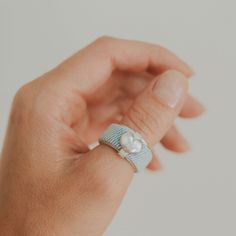 Modern light blue denim fabric ring with silver polished heart, diamond matt finish straps, and silver band with milgrain on the edges. The fabric is 100% cotton denim, handcrafted to make this fashionable statement ring. The metal used is Silver 925. Model wears EU size 59. Calliope is part of the Santorini Collection. Please Note: Each piece in our collection is unique, showcasing the natural beauty and individuality of the fabrics we choose. The colour of the fabric may appear slightly differ Blue Adjustable Heart Ring, Adjustable Blue Heart Ring, Fabric Ring, Blue Diamond Ring, Heart Diamond, Modern Light, Light Blue Denim, Blue Diamond, Silver Jewellery