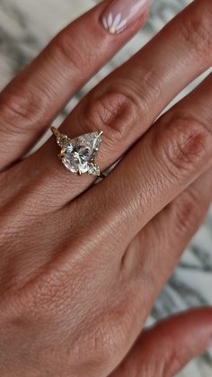 a woman's hand with a ring on her finger and a diamond in the middle