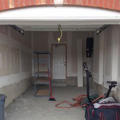 an empty garage with various tools and equipment in it, including vacuums and other household items