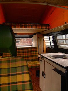 the interior of a camper with green and yellow plaid upholster