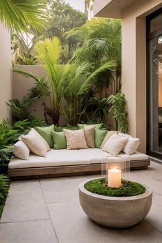 a couch sitting on top of a stone floor next to a lush green plant