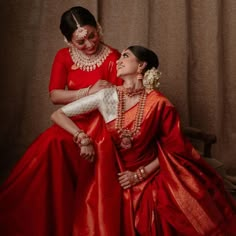 two women dressed in red posing for the camera