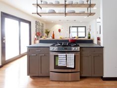 a stove top oven sitting inside of a kitchen next to a wooden floor and white walls