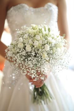 a bridal holding a bouquet of white flowers