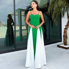 a woman in a green and white dress standing outside