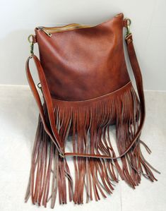 Bohemian fringe bag, cognac leather fringe bag, cognac brown boho bag, festival bag, leather crossbody, handmade leather bag This gorgeous bohemian style bag is crafted with a high quality suede leather and a cowchide leather. It has a top zip closure, and includes an inside pocket. It's cross body feature makes it suitable for a day or night occasion. Light in weight and unique. It is the perfect bag for every season. We use soft genuine leather. This bag is perfect as your everyday bag, which Bohemian Style Bag, Leather Fringe Bag, Chocolate Gold, Handmade Leather Bag, Brown Leather Backpack, Leather Rucksack, Leather Totes, Festival Bag, Fringe Bags