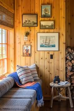 a living room with wood paneling and pictures on the wall