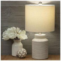 Base Dimensions: 6" W x 6" D Shade Dimensions: 9.25" H x 11" W x 11" D Full Height: 21" Cord Length: 65" Bulb Type: A 100W 3-Way Power Source: Corded Electric Material: Ceramic, Fabric & Metal Color: White, Beige, Cream & Silver Pattern: Stripes Quantity: 1 Add some visual appeal to your library or home office with this White & Brown Ribbed Table Lamp. It features a rounded body with a white and brown ribbed pattern around the exterior. Coordinate it with neutral tones for a cohesive room arrangement. Industrial Table Lamp Bedroom, Farmhouse Lamps Bedroom, Bedroom Table Lamps, Electric Material, Table Lamp Bedroom, Farmhouse Lamps, Room Arrangement, Industrial Table Lamp, Nursery Lamp