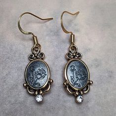 "These pair of earrings are made with a silver tone metal enamel. The enamel is engraved with a floral pattern with rhinestones. The earrings come with a nickel free wire closure. Earrings are light weight and comfortable to wear, making them ideal for everyday use. Earrings approximately drop 1 1/4\" from earlobe Please note actual colors may vary due to different device monitors & screen settings." Ornate Engraved Dangle Jewelry, Vintage Engraved Dangle Jewelry, Antique Engraved Drop Earrings, Vintage Etched Dangle Earrings, Vintage Engraved Dangle Earrings, Heart Dangle Earrings, Blue Rhinestones, Floral Pattern, Silver Tone