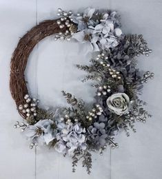 a wreath with flowers and greenery hanging on the wall